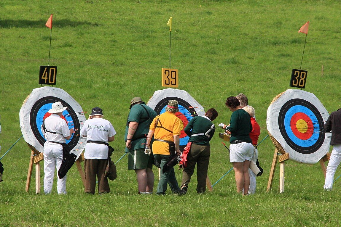 Archers collecting arrows and scoring the target at an archery competition