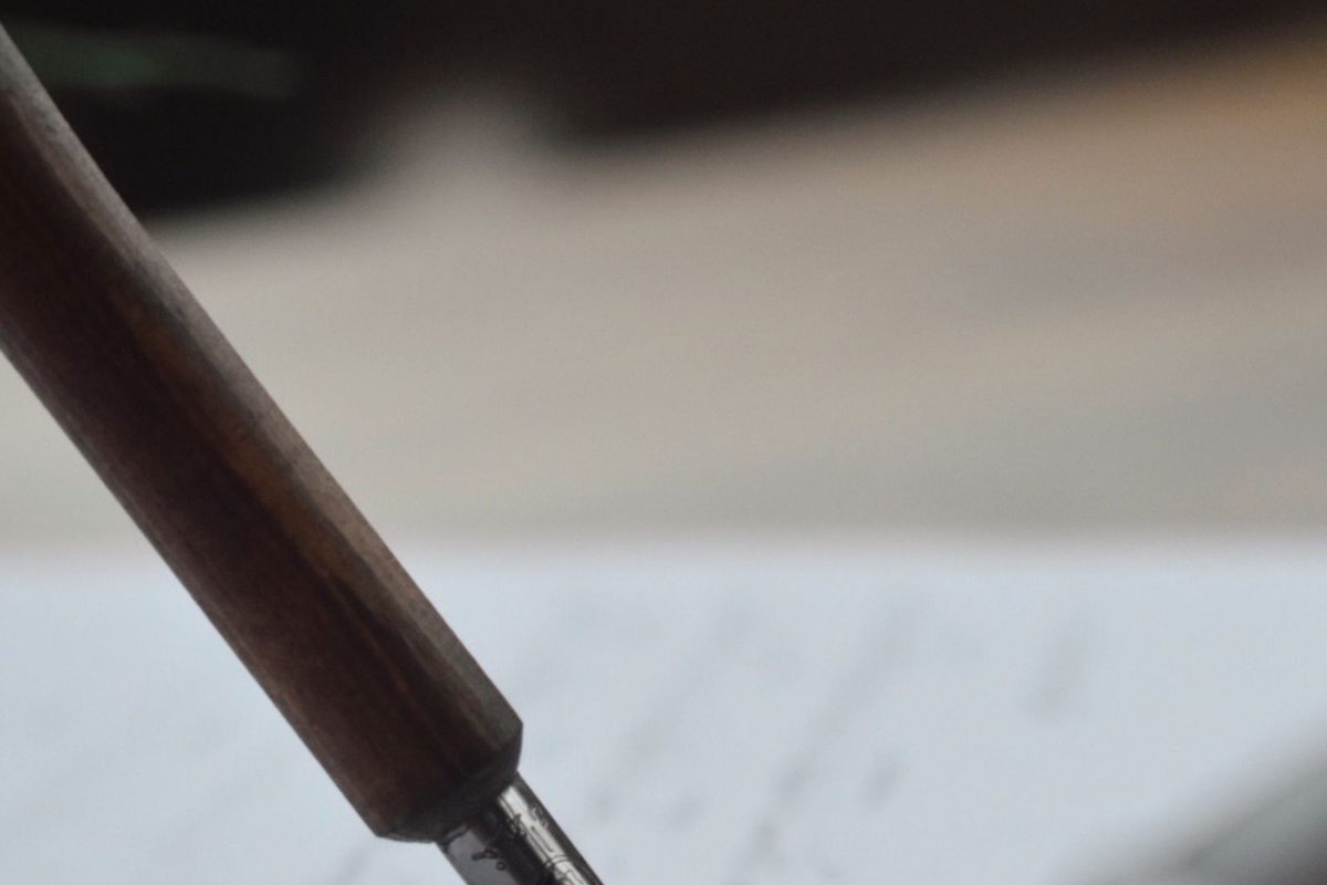 A fountain pen writing cursive script on paper